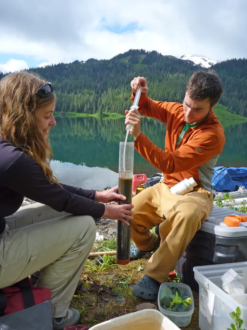 Researchers processing a fresh sediment core on a mountain lakeshore