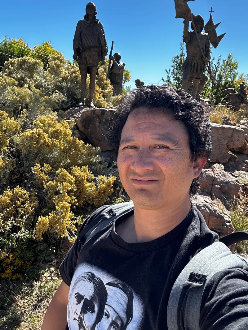 Frank Telles stands in front of the Juan de Oñate monument in Albuquerque, representing the 1598 onset of Spanish colonization in the Southwest. As the Columbine Lake record reveals, the extractive agricultural practices and exotic livestock introduced during this era destroyed the native vegetation blanket, ultimately triggering the unprecedented 1667 CE dust regime shift.